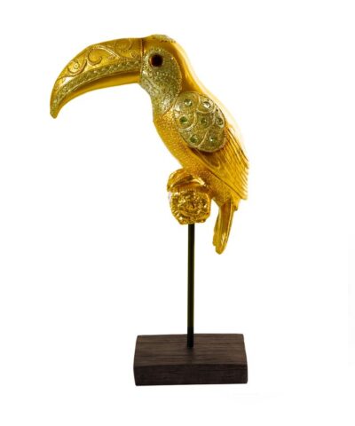 Tukan złota figurka dekoracyjna na eleganckiej podstawce.