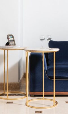 Złoty stolik w pomieszczeniu nowoczesnym glamour podkreśla granatowy kolor.
